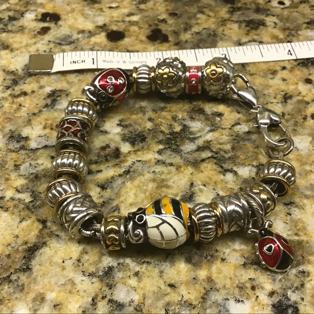 Brighton silvertone bracelet with 17 barrel type charms